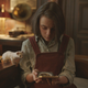 Lyra (Dafne Keen) looks over the alethiometer.
